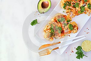 Cauliflower steaks, above view scene over marble with copy space, healthy plant based meat substitute concept