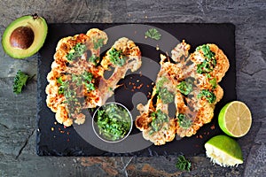Cauliflower steaks above view on a slate platter, healthy plant based meat substitute concept