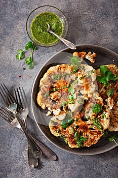 Cauliflower steaks with herb sauce and spice. plant based meat substitute