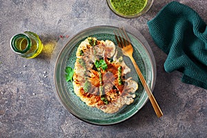 cauliflower steaks with herb sauce and spice. plant based meat substitute