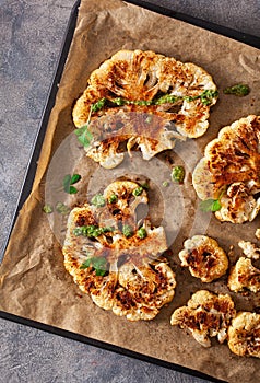 Cauliflower steaks with herb and spice on baking tray. plant based meat substitute