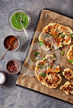 Cauliflower steaks with herb and spice on baking tray. plant based meat substitute