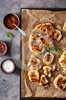 cauliflower steaks with herb and spice on baking tray. plant based meat substitute