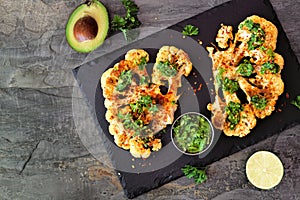 Cauliflower steaks top view on a slate background, healthy plant based meat substitute concept