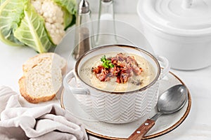 Cauliflower and white bean cream soup with fried bacon