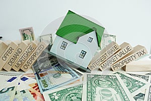 The causes of the real estate crisis with with falling house on cash banknotes