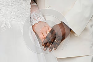 Causian and African couple holding hand with ring