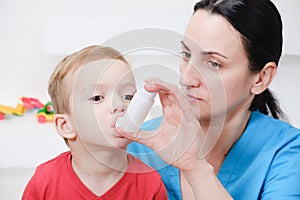 Causian little boy making inhalation with nebulizer at hospital