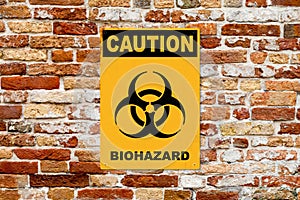 Caution - Biohazard sign on a brick wall