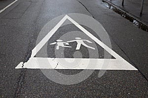 Caution: Children Playing - Urban Street Safety Sign on Wet Pavement