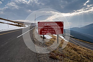 Caution - dangerous snowfields ahead sign, keep off steep slopes along Trail Ridge Road in Rocky Mountain National Park Colorado photo