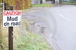 Caution mud on road sign at bend