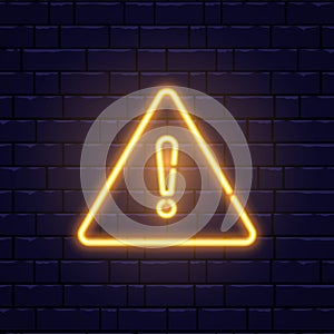 Caution neon sign on brick wall. Glowing gold exclamation mark icon. Warning symbol. Attention button. Realistic night