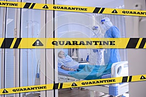 Caution on quarantine area sign in front of quarentine room with background of patient