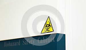 The Caution sign `Biological HazardÃ¢â¬Â for warning inflected biohazard area, a safety sign warning on biosafety cabinet in lab. photo