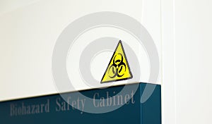 The Caution sign `Biological Hazardâ€ for warning inflected biohazard area, a safety sign warning on biosafety cabinet in lab.