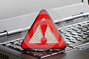 Caution sign on black laptop computer virus detected alert hacking piracy photo