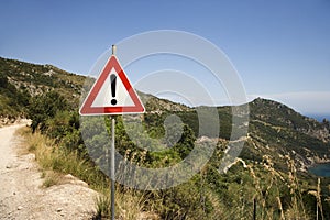 Caution sign on coastal dirt road.