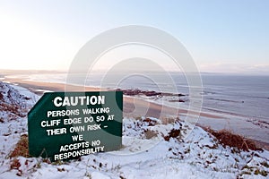 Caution sign on hazardous cliff edge