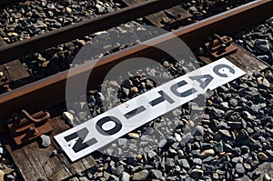 Caution sign beside railway track.