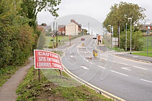 Caution site entrance lorries turning warning road sign on British road daylight view