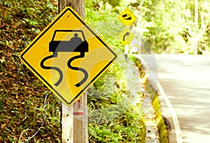 Caution of slippery roads - traffic signs beside country road