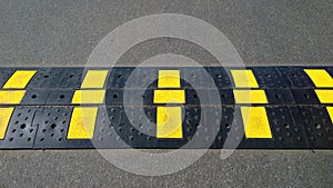 Caution speed bump with Illuminating yellow rectangles. Sleeping policeman. Gray grunge asphalt background. Road safety regulation