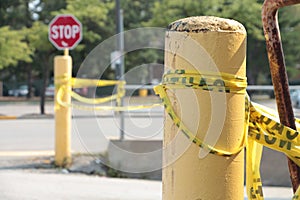 caution tape yellow black tied bunched around yellow posts a bunch of times 76 p 20