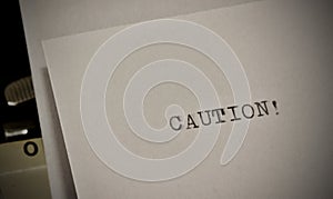 Caution text typed on old black typwriter