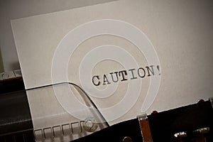 Caution text typed on old black typwriter