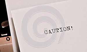 Caution text typed on old black typwriter
