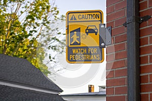 Caution watch for pedestrians yellow black street sign with figure and car graphics and star where injury may occur