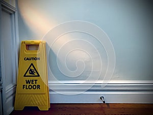 A Caution Wet Floor sign is behind the door.