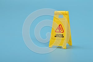 Caution wet floor sign isolated on a blue background. Copy space for the text