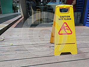 Caution wet floor warning sign with blurred on the wooden floor