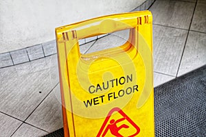 Caution wet floor warning sign in a public swimming pool