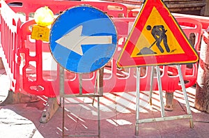 Caution work in progress sign and a large arrow to divert traffic to the construction site photo