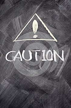 Caution written on blackboard