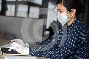 Cautious female worker adhering quarantine measures at workplace.