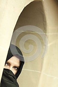 Cautious Islamic Woman in Window Pane Wearing Burqa or Niqab