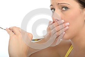 Cautious Unhappy Natural Young Woman Holding a Spoonful of Salt photo