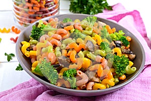 Cavatappi colored pasta with broccoli and mushrooms on a white wooden background. Pasta colorata. Pasta with vegetables
