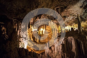 Cave dark interior with light, stalactites and stalagmites