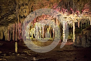 Cave dark interior with light, stalactites and stalagmites