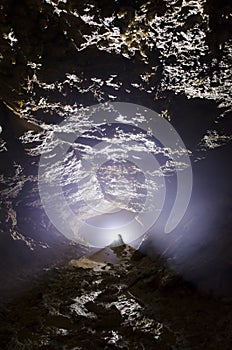 Cave entracne with light and stalagmite photo