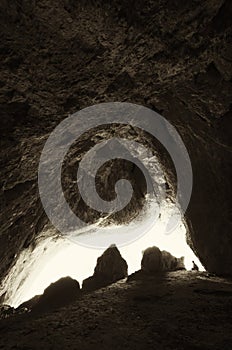 Cave entrance with silhouette of man standing