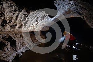 Cave explorer, spelunker, archeologist studying underground passage photo