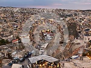 Cave houses and volcanic landscape of Cappadocian town Goreme in the evening