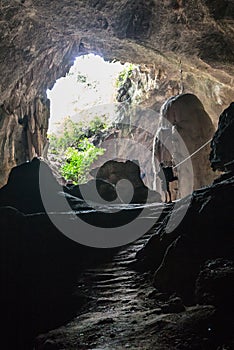 Cave with man standing on a rock in front of the entrance