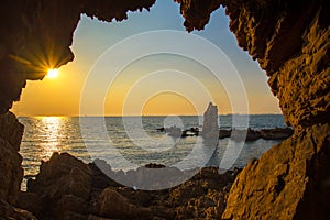The cave near the sea on the sunset